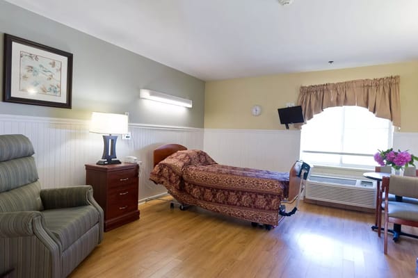 Private resident room with a comfortable chair and bed