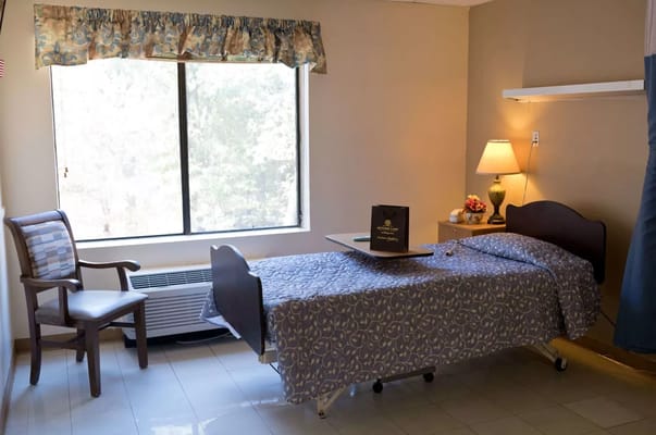 Interior view of a private resident room with a bed