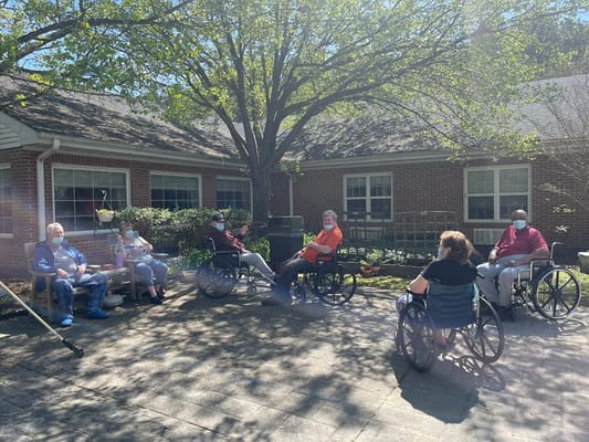 Group of residents in wheelchairs gathered in the courtyard