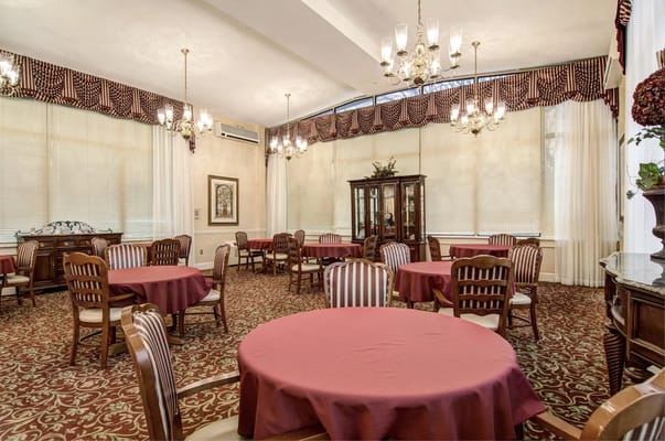 Bright dining room with round tables and chandeliers