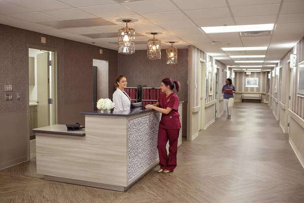 Staff at reception desk in a well-lit hallway