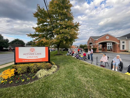Residents seated outside the facility with building in view