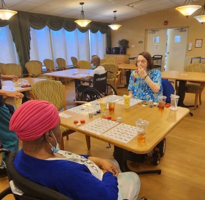Residents playing bingo in a cozy common area.