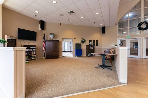 Spacious common area with seating and TV at Autumn Lake Healthcare.