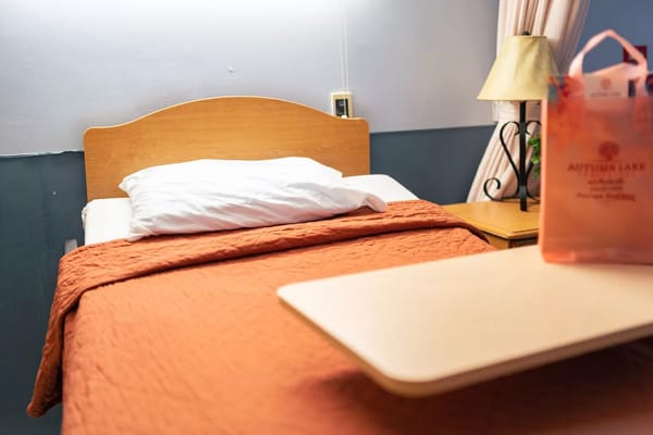 Cozy bedroom with an orange quilt and bedside lamp