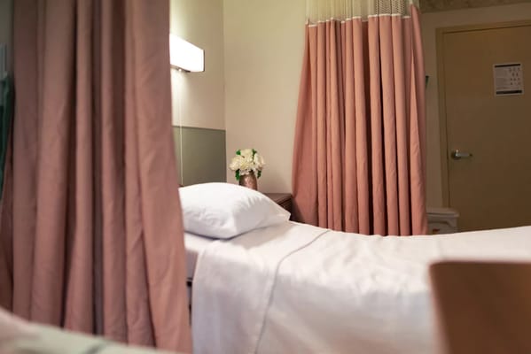 Private resident room with hospital bed and curtains