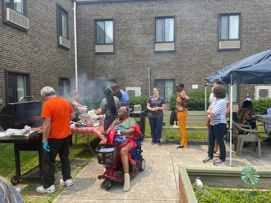 Residents and staff enjoying a barbecue in the courtyard