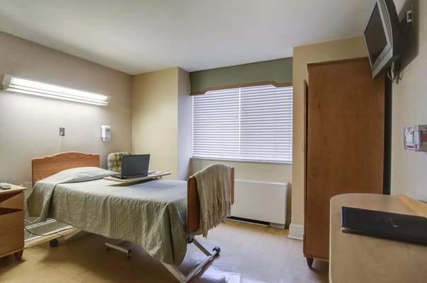 A private resident room with a bed and workstation