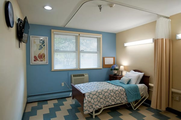 A private resident room with a bed and window