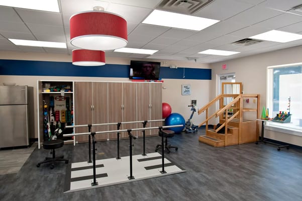 A physical therapy room with exercise equipment and steps