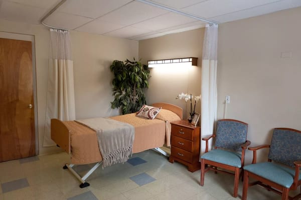 A cozy resident room with a bed and seating area
