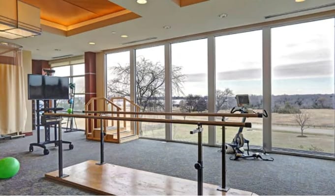 Fitness area with large windows overlooking green space