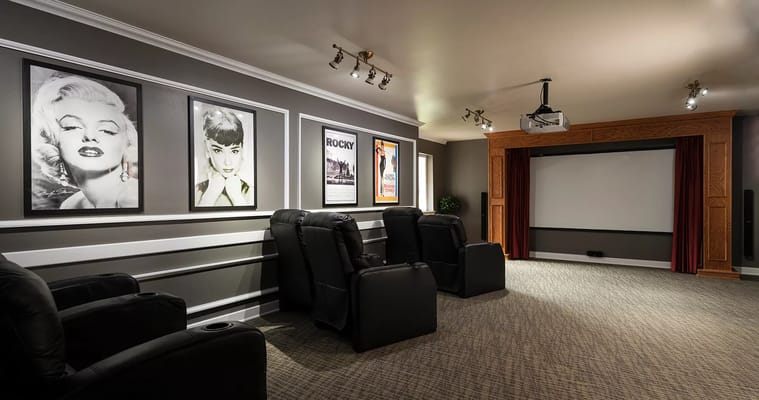Interior of a movie theater with leather recliners and framed classic movie posters