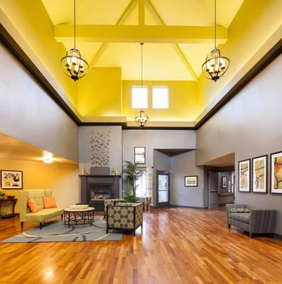 Spacious lobby with seating, large windows, and vibrant decor.