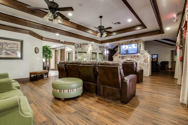 A cozy common area in the nursing home with seating and a TV