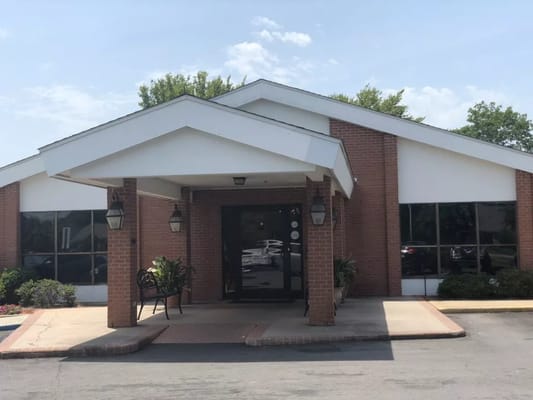 Front entrance of Avalon Place of Monroe with landscaping and seating area
