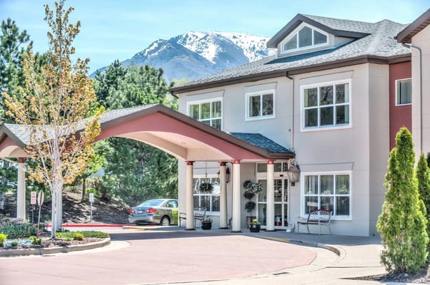 Entrance of a senior living facility with mountains in the background