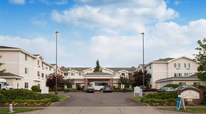 Exterior view of a senior living facility with gardens