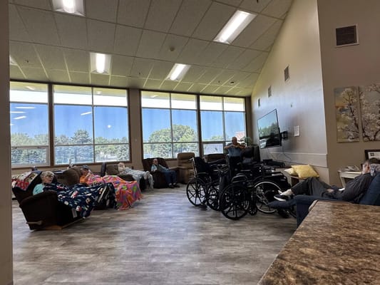 Residents relaxing in a common area filled with natural light