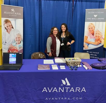 Staff members at an event booth for Avantara Milbank