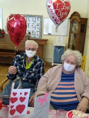 Residents celebrating with balloons and decorations in a common area