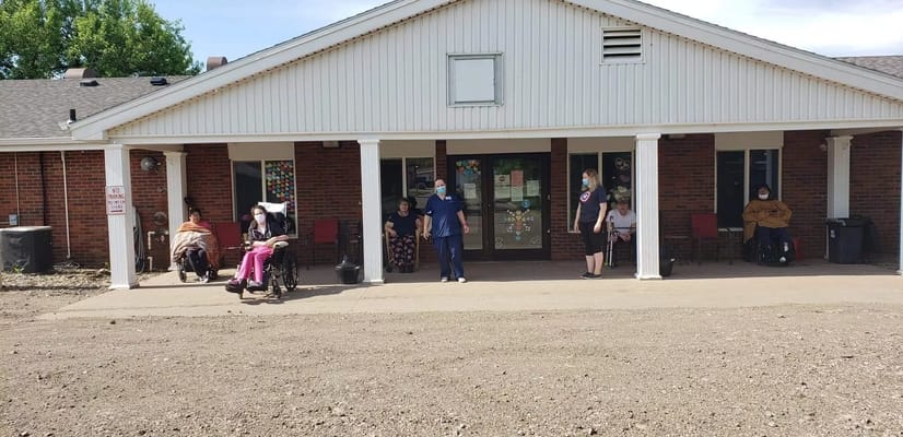 Residents and staff outside the facility building