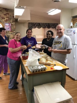 Residents and staff preparing food together in the kitchen