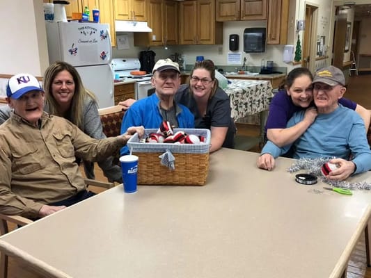 Residents and staff gathered around a table with crafts