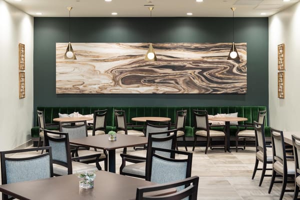 Modern dining area with green booth seating and decorative wall art