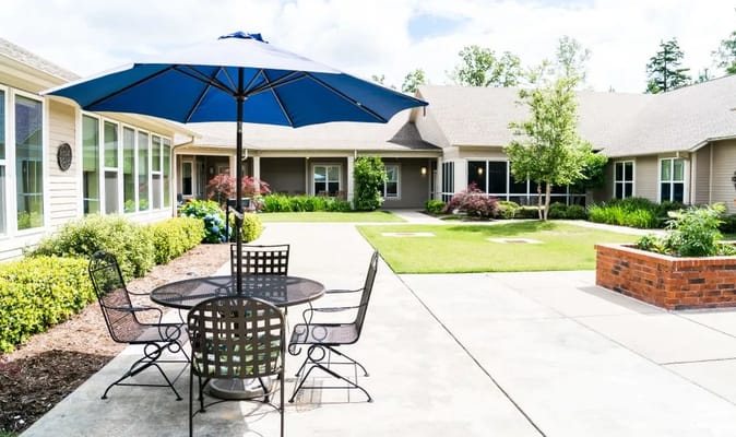 Outdoor space with tables and chairs under an umbrella