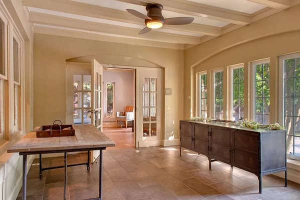 Bright entry area featuring a wooden table and large windows.
