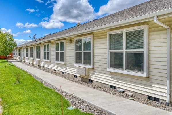 Single-story building with many windows and a pathway in front