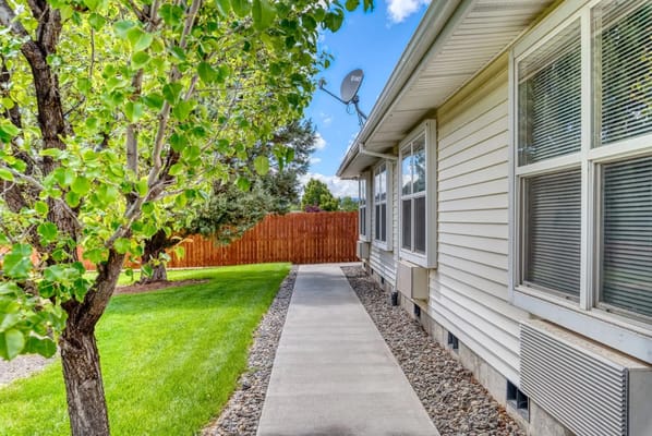 Concrete walkway lined by greenery at Awbrey Place Assisted Living