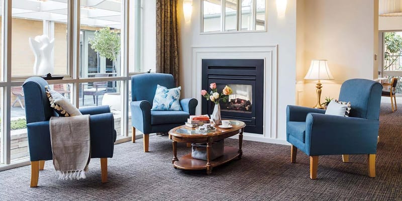 Cozy common area with blue chairs and a coffee table