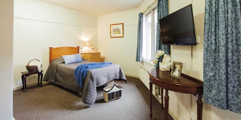 A cozy resident room with a bed and window