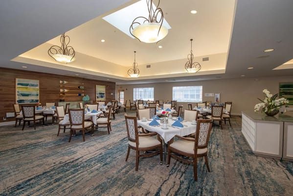 Well-lit dining room with neatly set tables and cozy decor