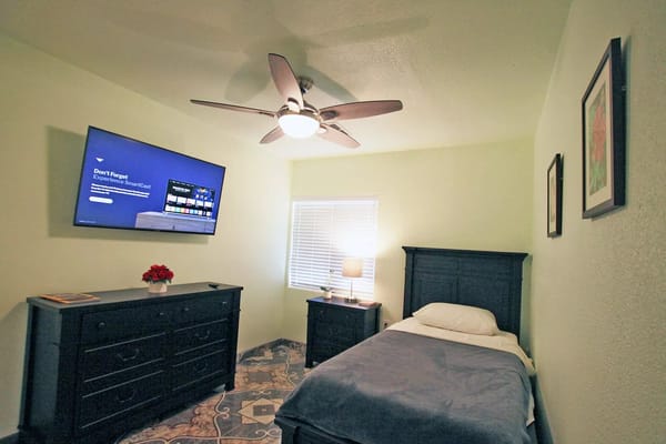 Cozy private bedroom with a TV and dresser