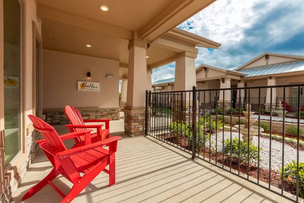 Bright outdoor seating area with red chairs and garden