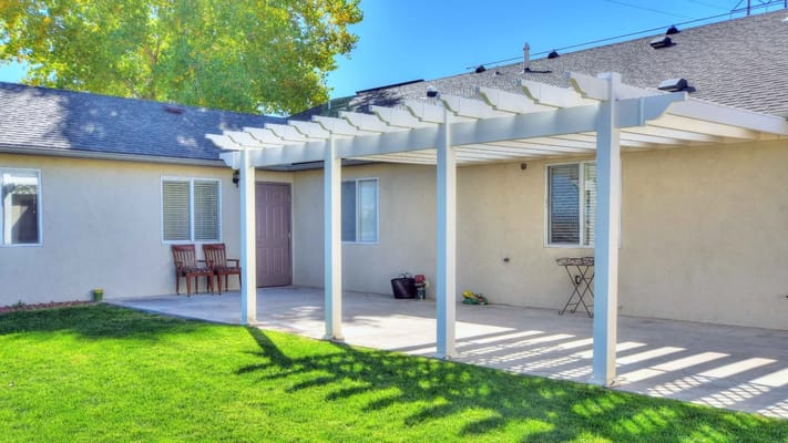 Outdoor patio area with a pergola and chairs