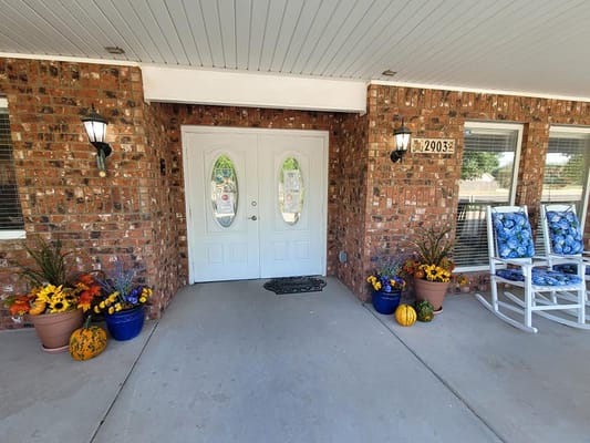Entrance with flowers and blue rocking chairs