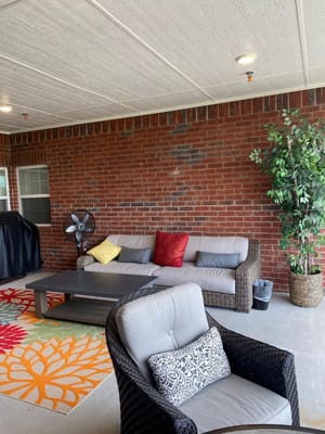 Outdoor seating area with couch and fan