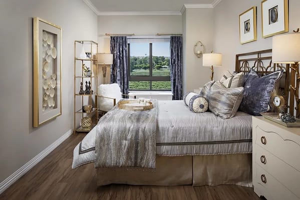 Stylish bedroom with a bed, decorative pillows, and a window view.