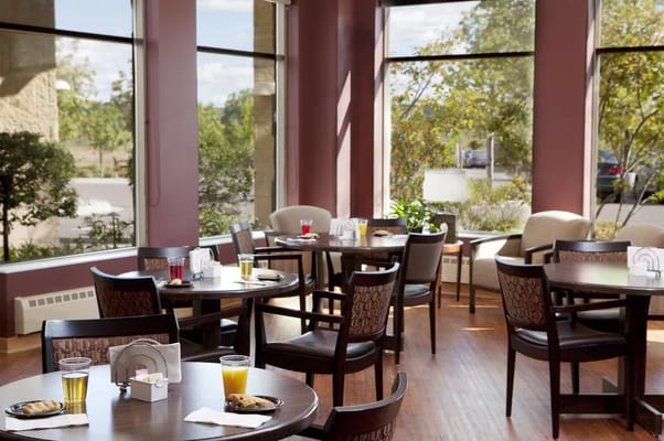 Dining room with tables and beverages near large windows