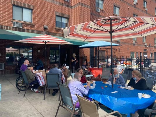 Residents enjoying a meal outside under umbrellas
