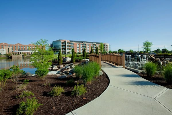 Pathway leading to a small waterfall near a senior living facility.
