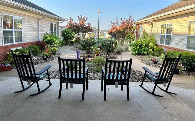 Rocking chairs overlooking a beautifully landscaped garden