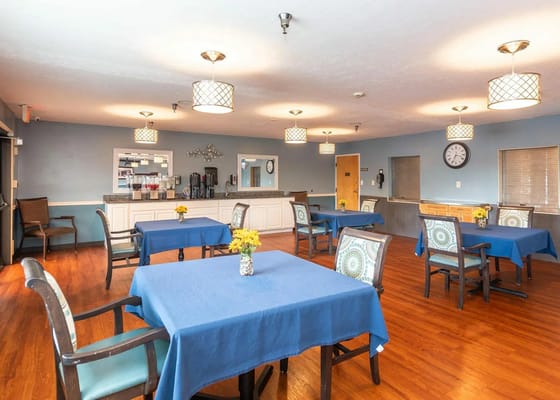 Bright dining area with blue tablecloths and floral centerpieces