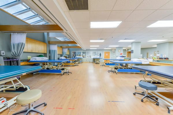 Spacious rehabilitation room with therapy tables