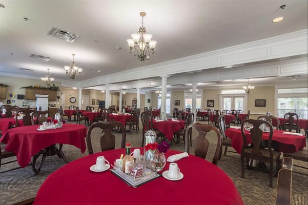 Dining area with red tablecloths and chairs