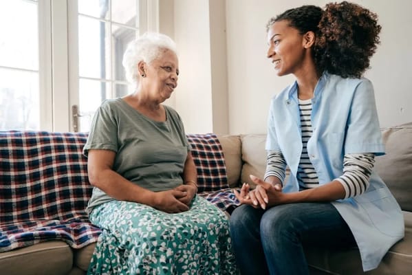 Staff member conversing with a resident in a cozy living area